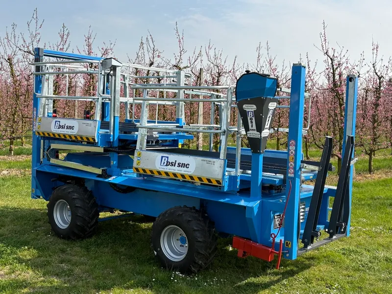 Carro raccolta frutta Bosi SRL nel frutteto romagnolo, macchina semovente tra peschi in fiore, Faenza